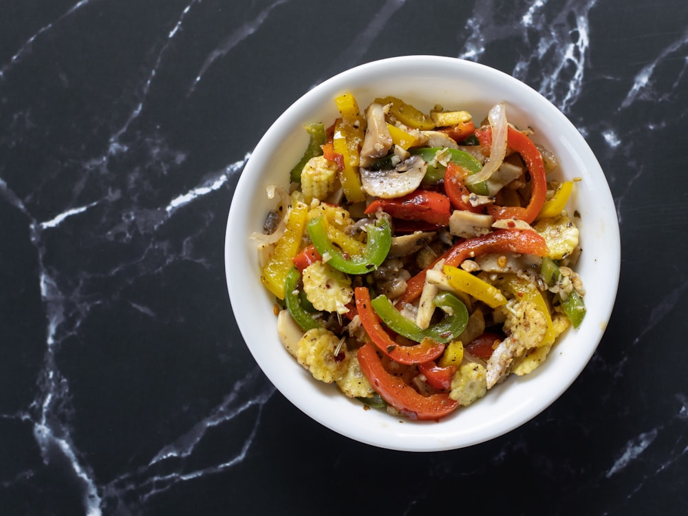 a white bowl filled with vegetables on top of a table