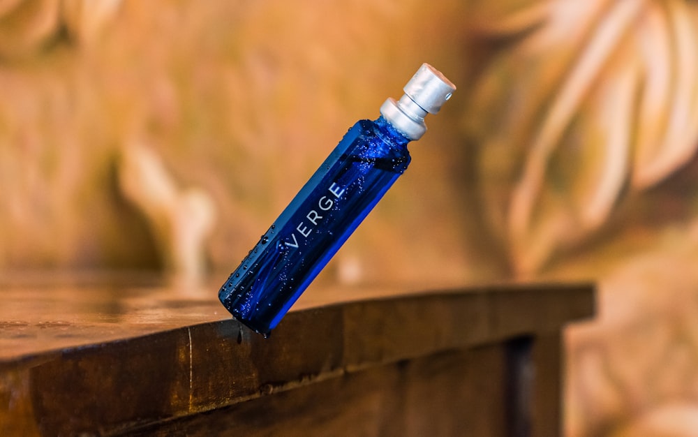 a blue bottle sitting on top of a wooden table