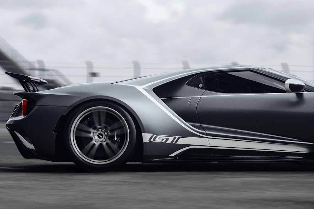 a gray sports car driving down a road