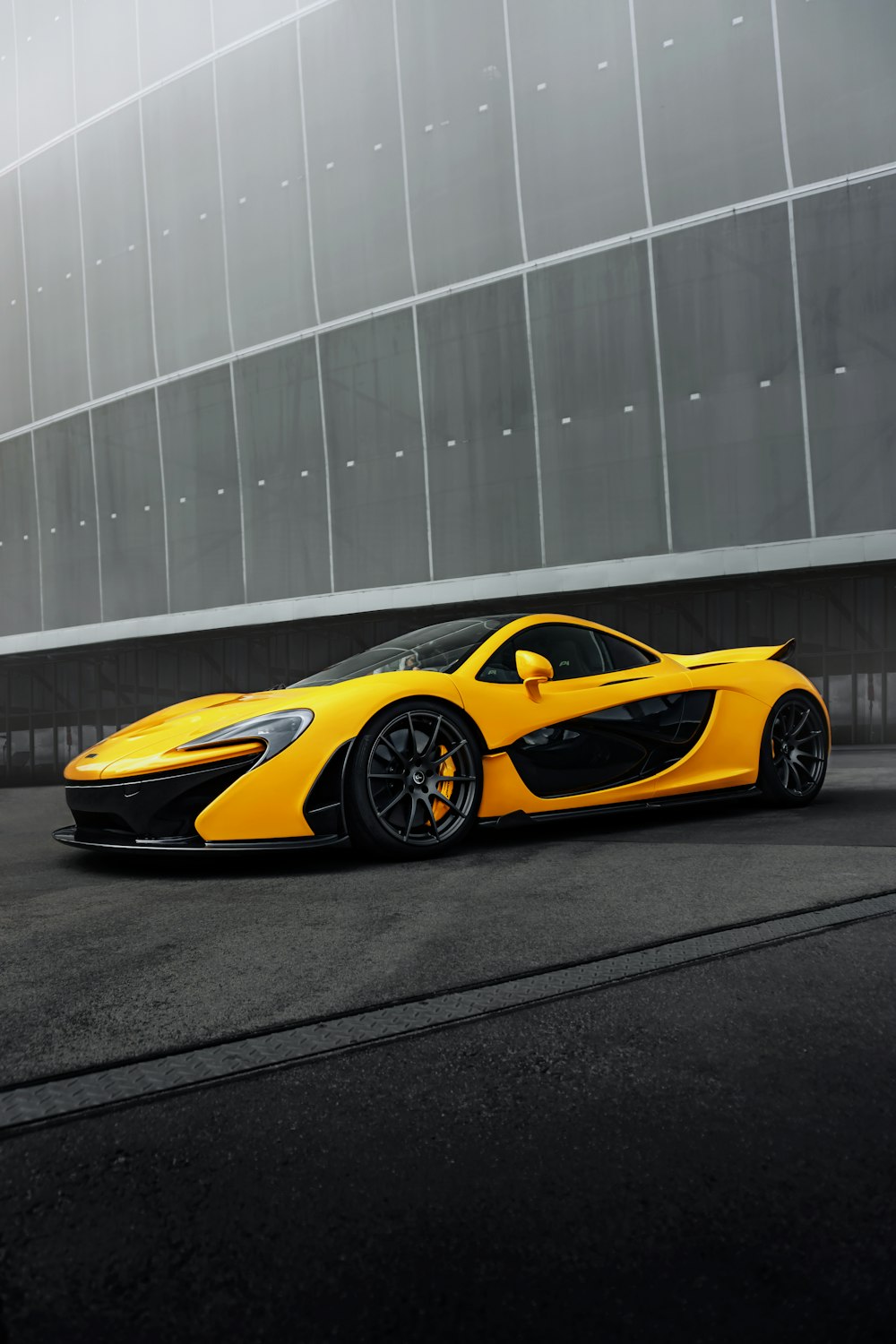 a yellow sports car parked in front of a building