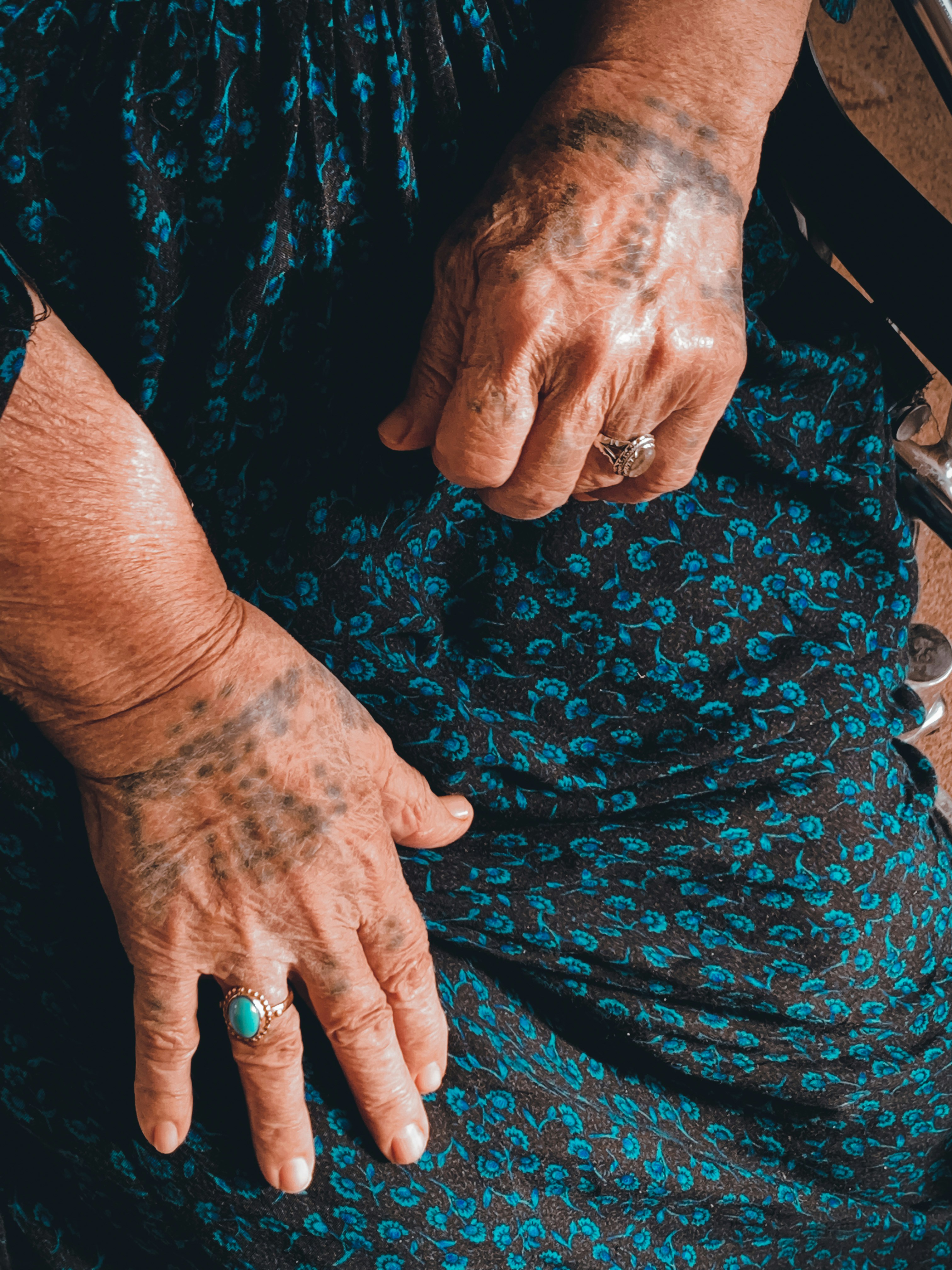 a person with tattoos on their hands sitting down