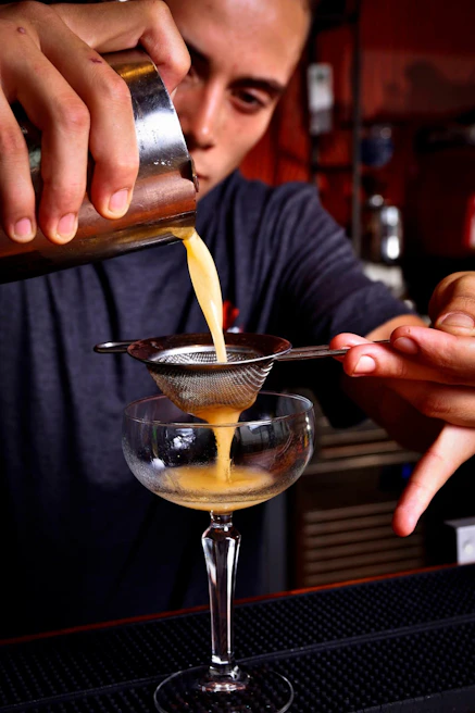 Close-up of a bartender crafting a signature cocktail with sparkling wine