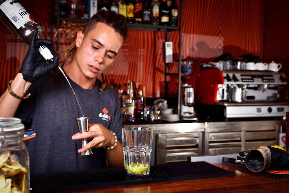 um homem está fazendo uma bebida em um bar