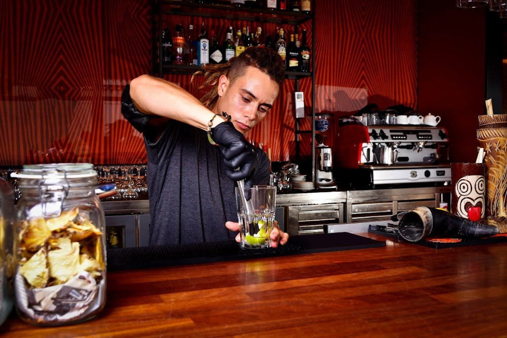 a man in a bar making a drink