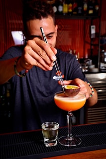 a man is making a drink at a bar