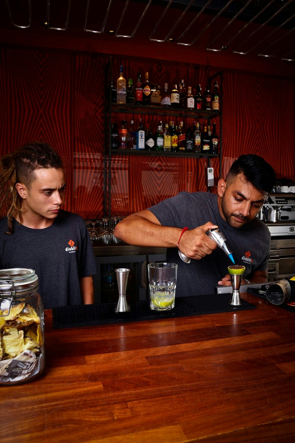 a man and a woman behind a bar making drinks
