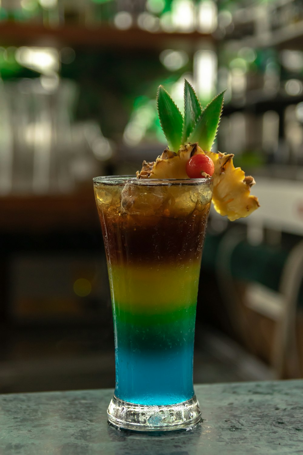 a tall glass filled with a colorful drink