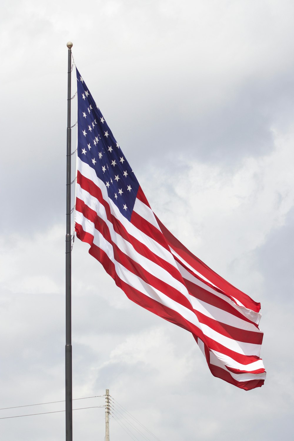 a large american flag flying in the wind