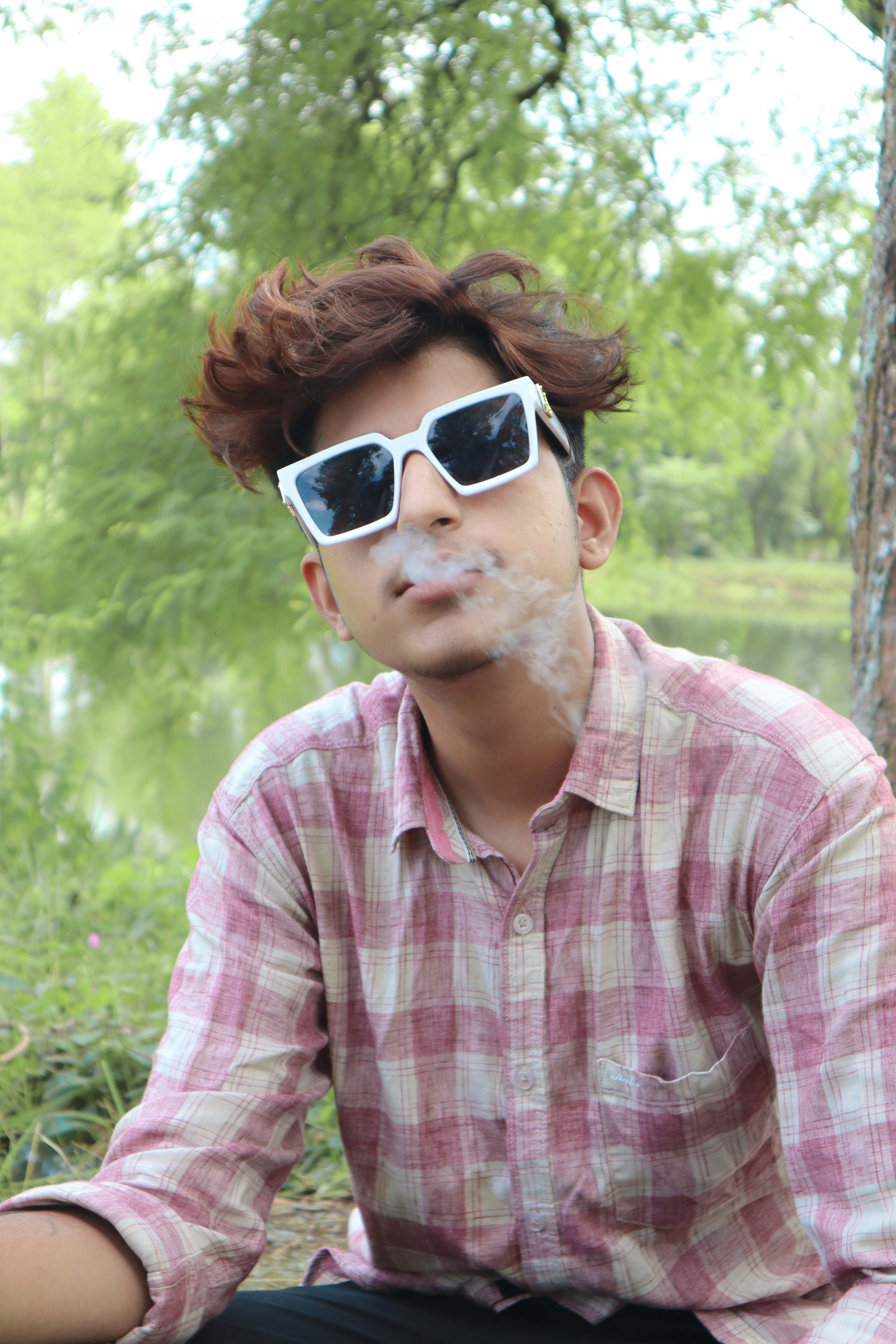um homem com óculos escuros e um cigarro na boca