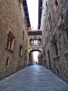 a narrow alley with a stone walkway between two buildings