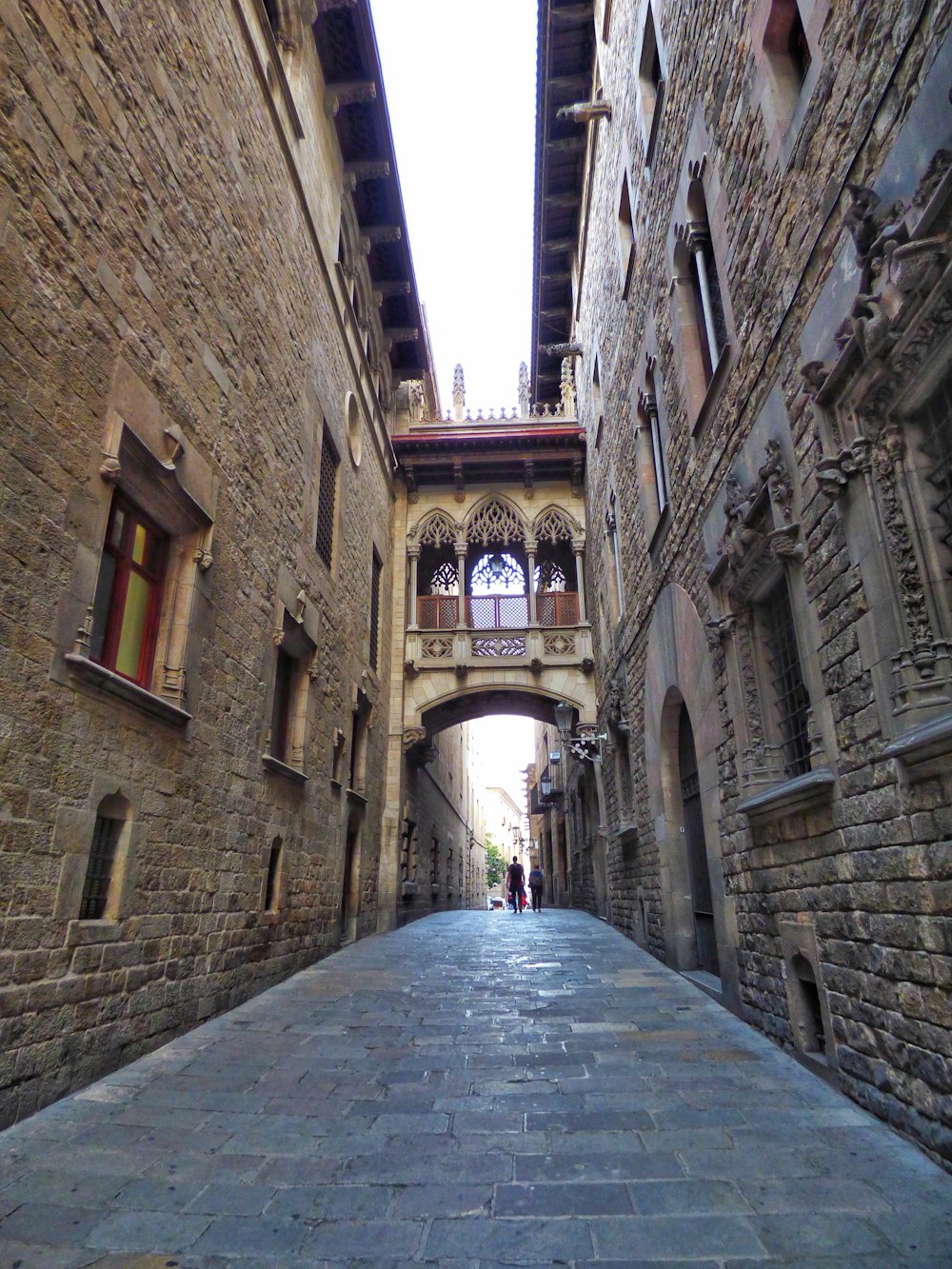 a narrow alley with a stone walkway between two buildings
