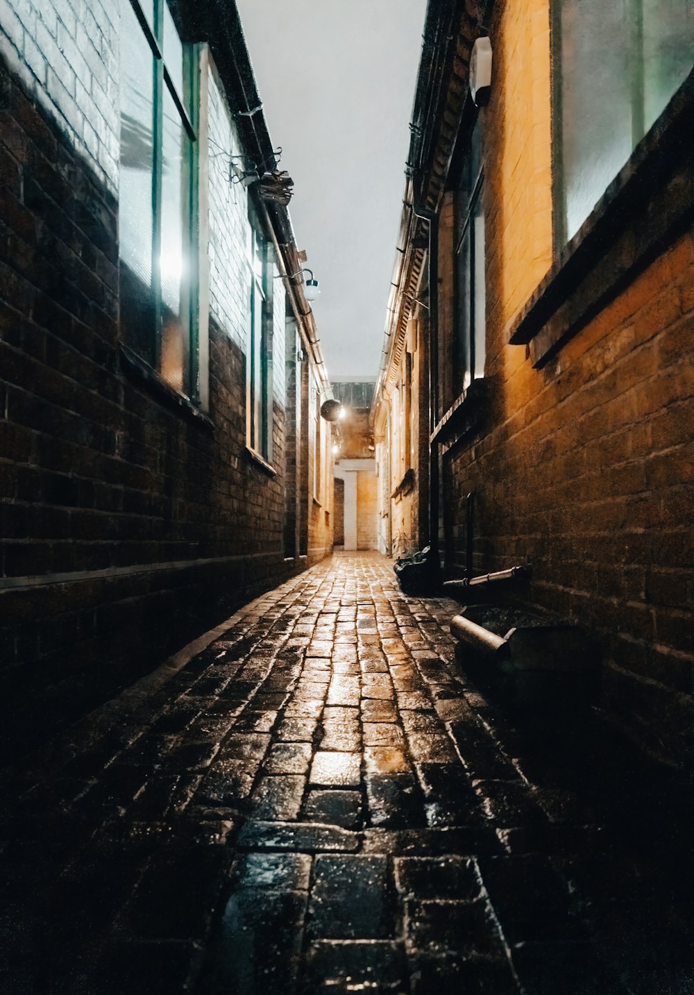a narrow alley way with brick walls and windows