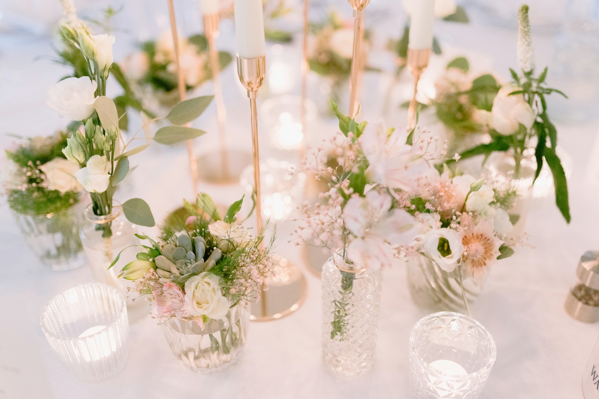 a table topped with lots of vases filled with flowers