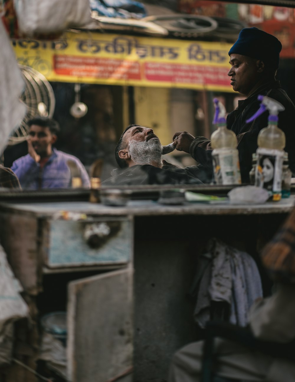 a man sitting at a barber shop with a white beard