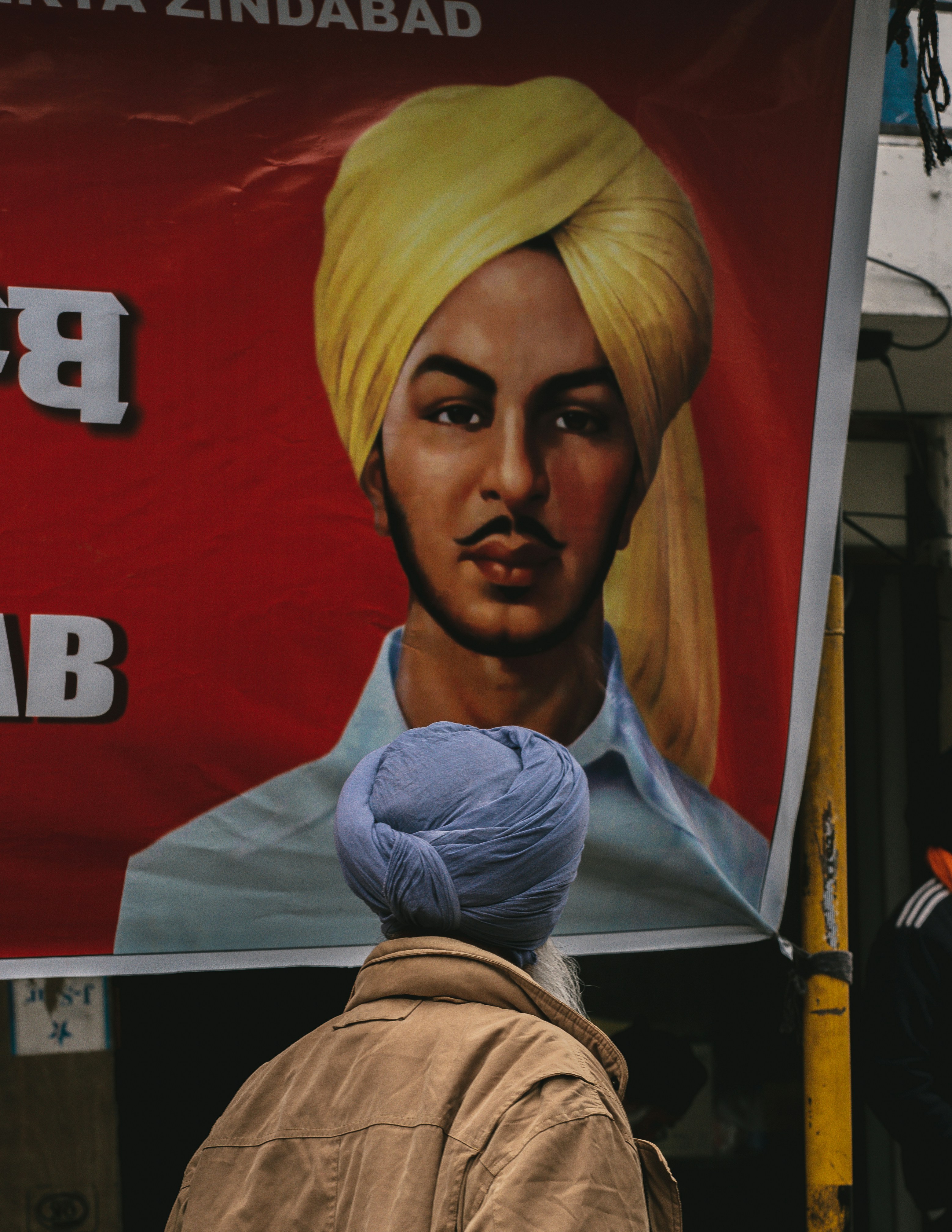 A man standing in front of a poster of a man with a turban photo – Free ...