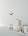 a white vase sitting on top of a white table