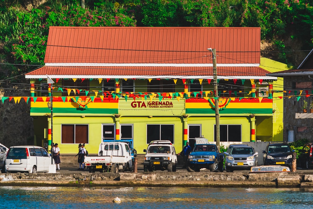 a group of cars parked in front of a yellow building