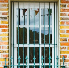 a window with bars and a bench in front of it
