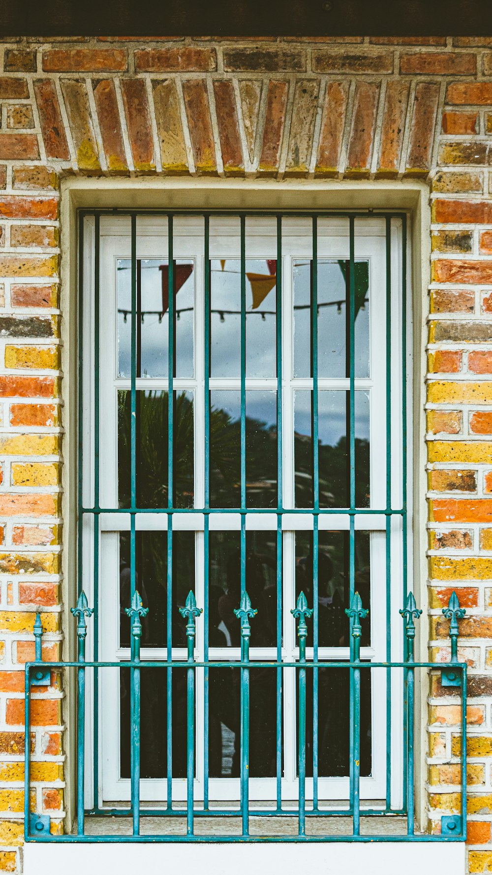 ein Fenster mit Gittern und einer Bank davor