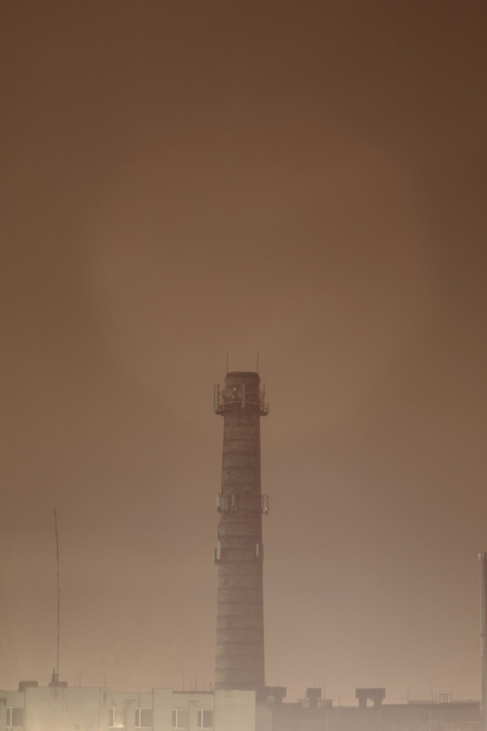 a tall tower sitting in the middle of a foggy sky