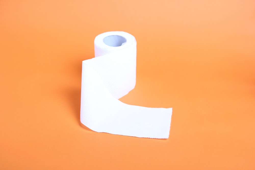 un rollo de papel higiénico sobre un fondo naranja