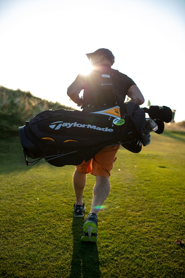 Golfeur marchant sur le fairway, sac à l'épaule, au soleil couchant