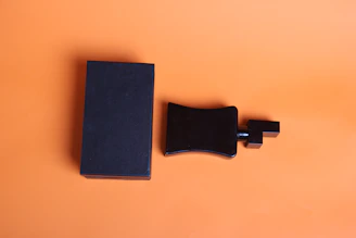 a black book and a black object on an orange background