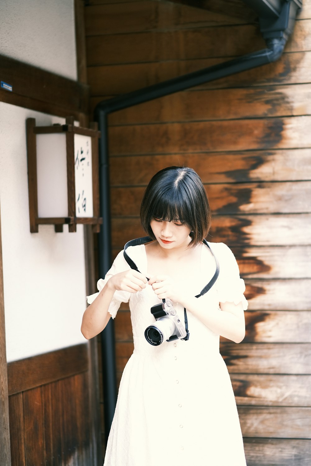 a woman in a white dress holding a camera