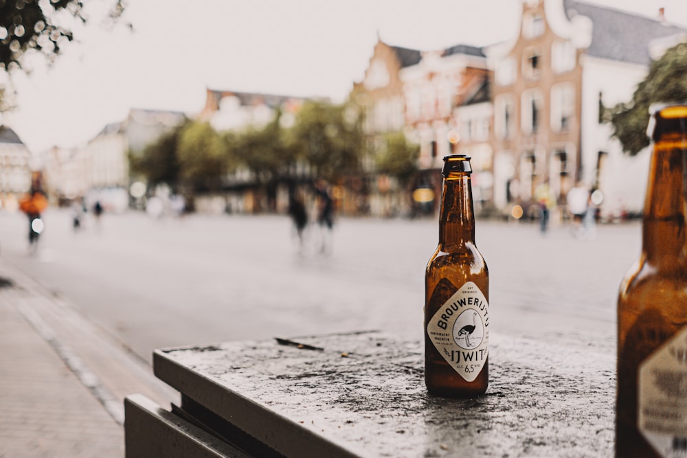 two beer bottles sitting on top of a wooden table