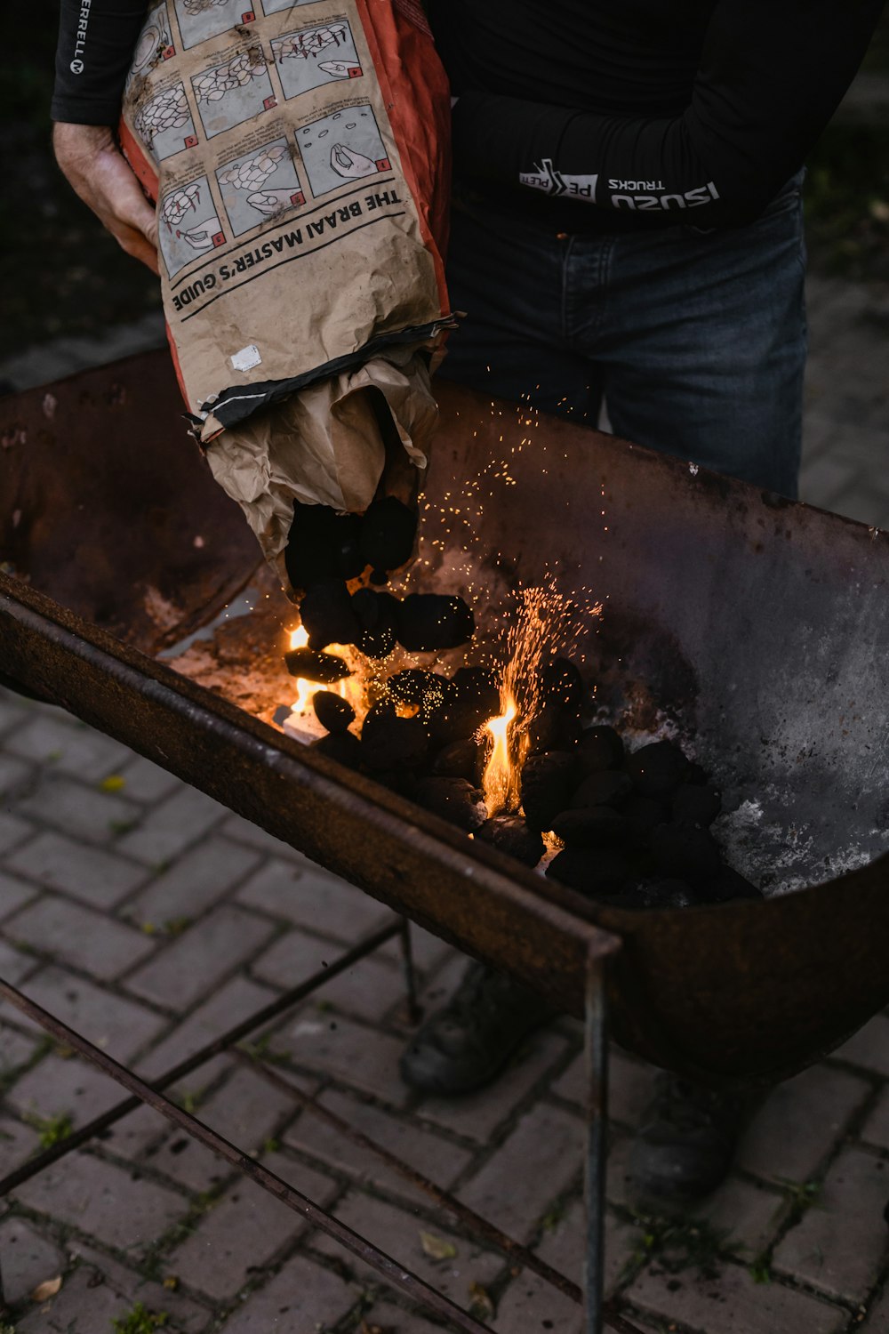 a person holding a bag over a fire pit