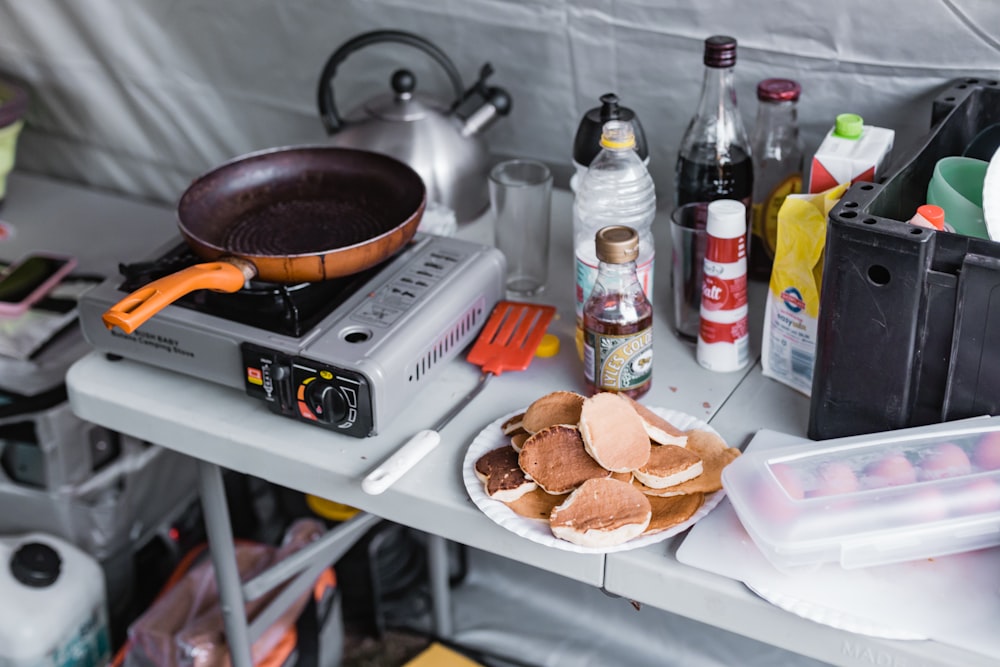 a table topped with a plate of food and a frying pan