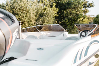 Detailed view of a polished and tinted boat windshield with stainless steel supports.