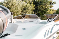 Close-up of hands steering a sleek electric boat’s wheel, with water sparkling in the background.