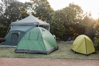 a couple of tents sitting on top of a lush green field