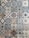 A collection of intricately designed ceramic tiles with various geometric and floral patterns. Each tile features unique motifs with combinations of blue, beige, and terracotta colors. The patterns range from symmetrical star shapes to more organic floral designs, providing a vintage and artistic appearance.