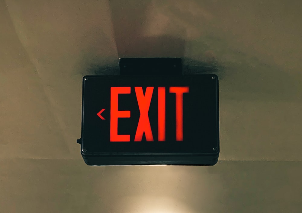 a red exit sign hanging from the ceiling