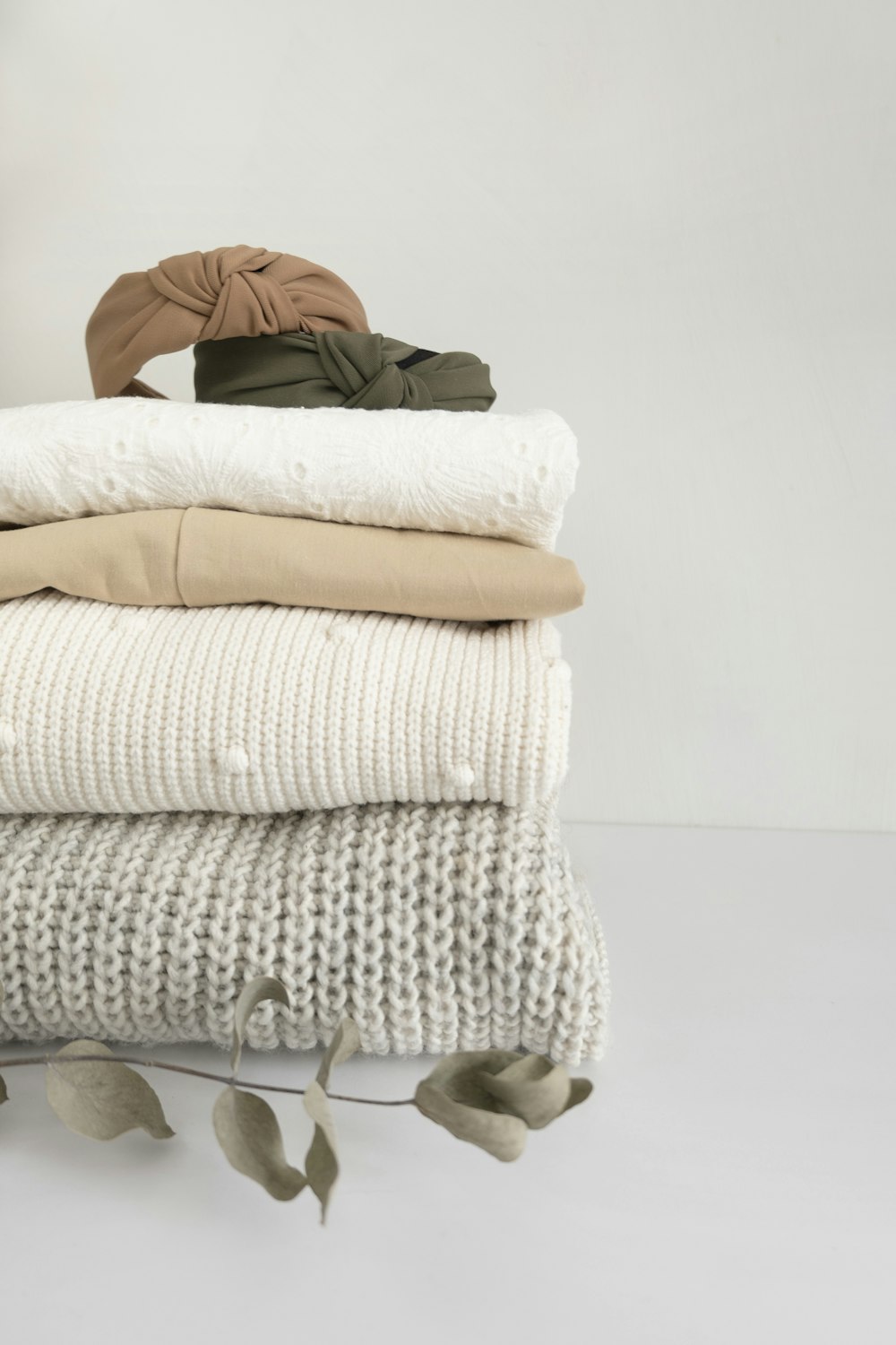 a stack of folded clothes on a white surface