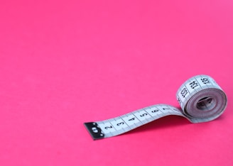a measuring tape on a pink background