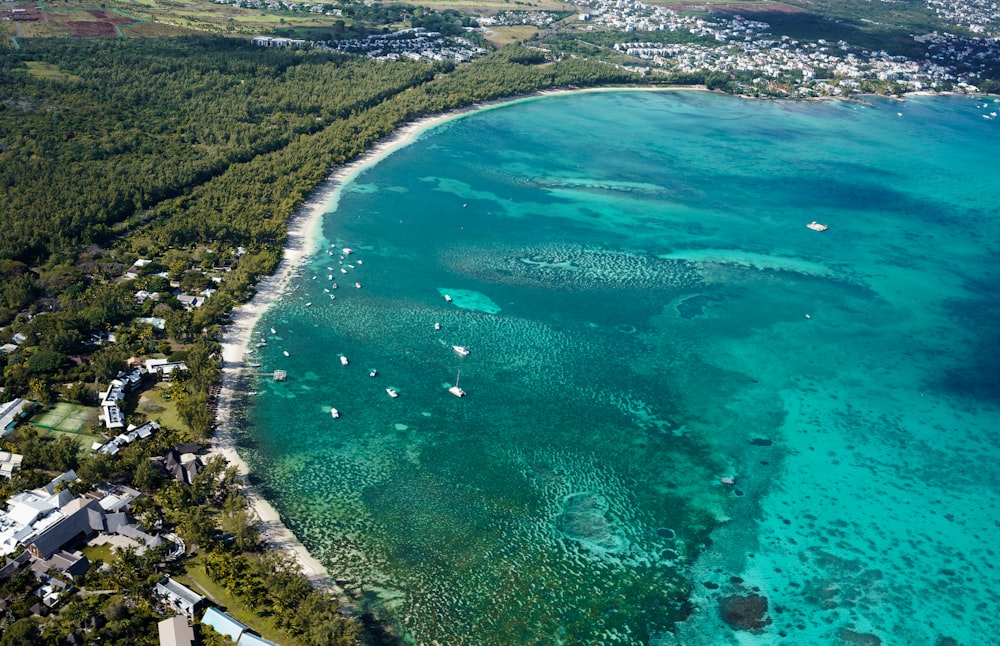 an aerial view of a beach with boats in the water