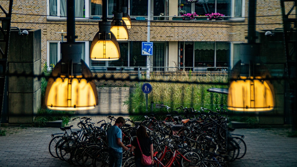 a couple of people standing next to a bunch of bikes