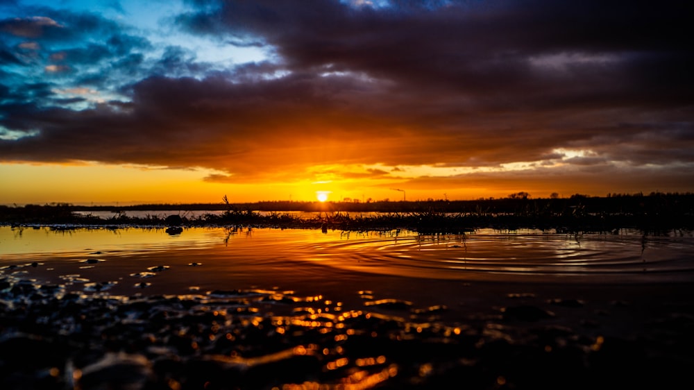 the sun is setting over a body of water