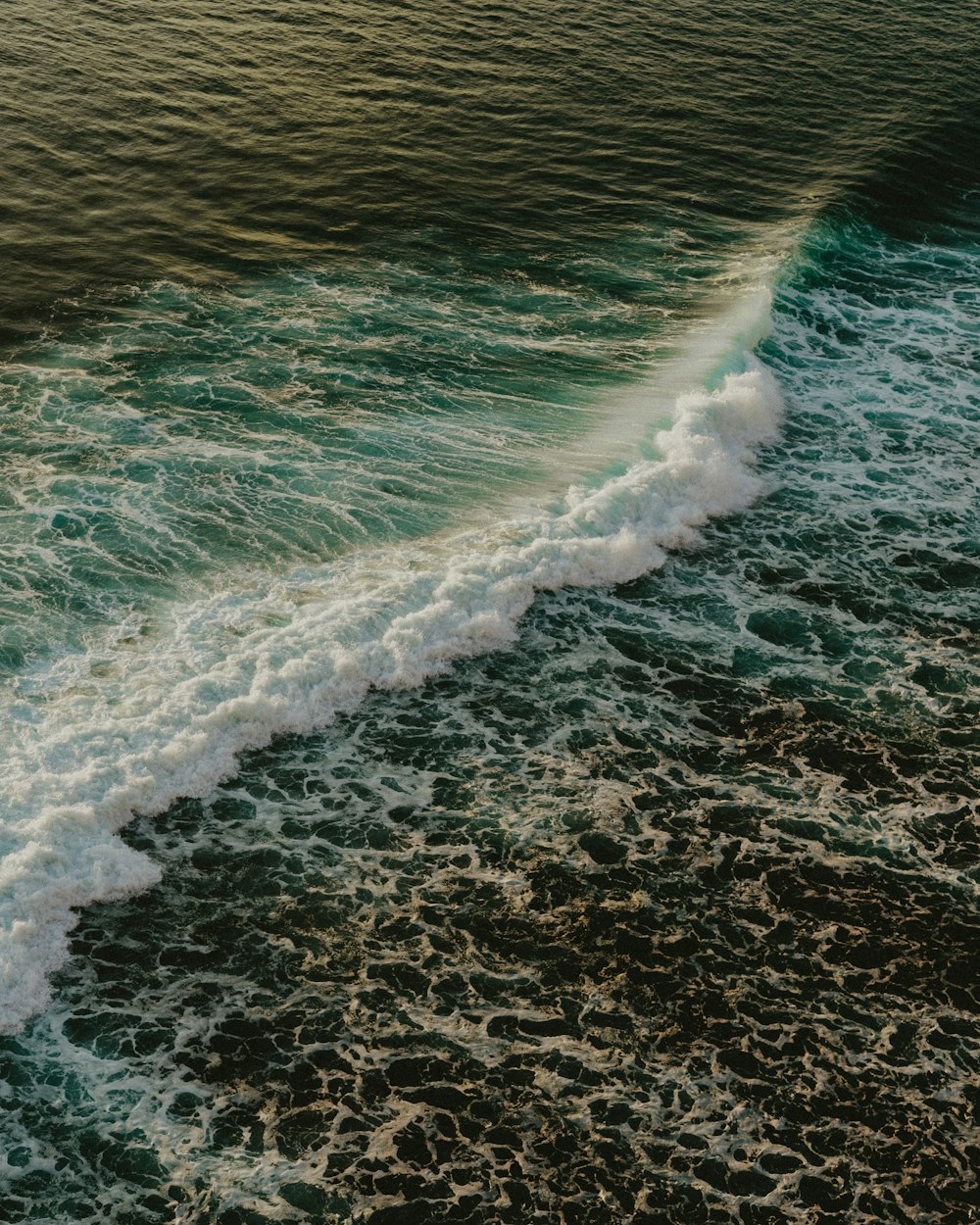 a wave is coming in to the shore of the ocean