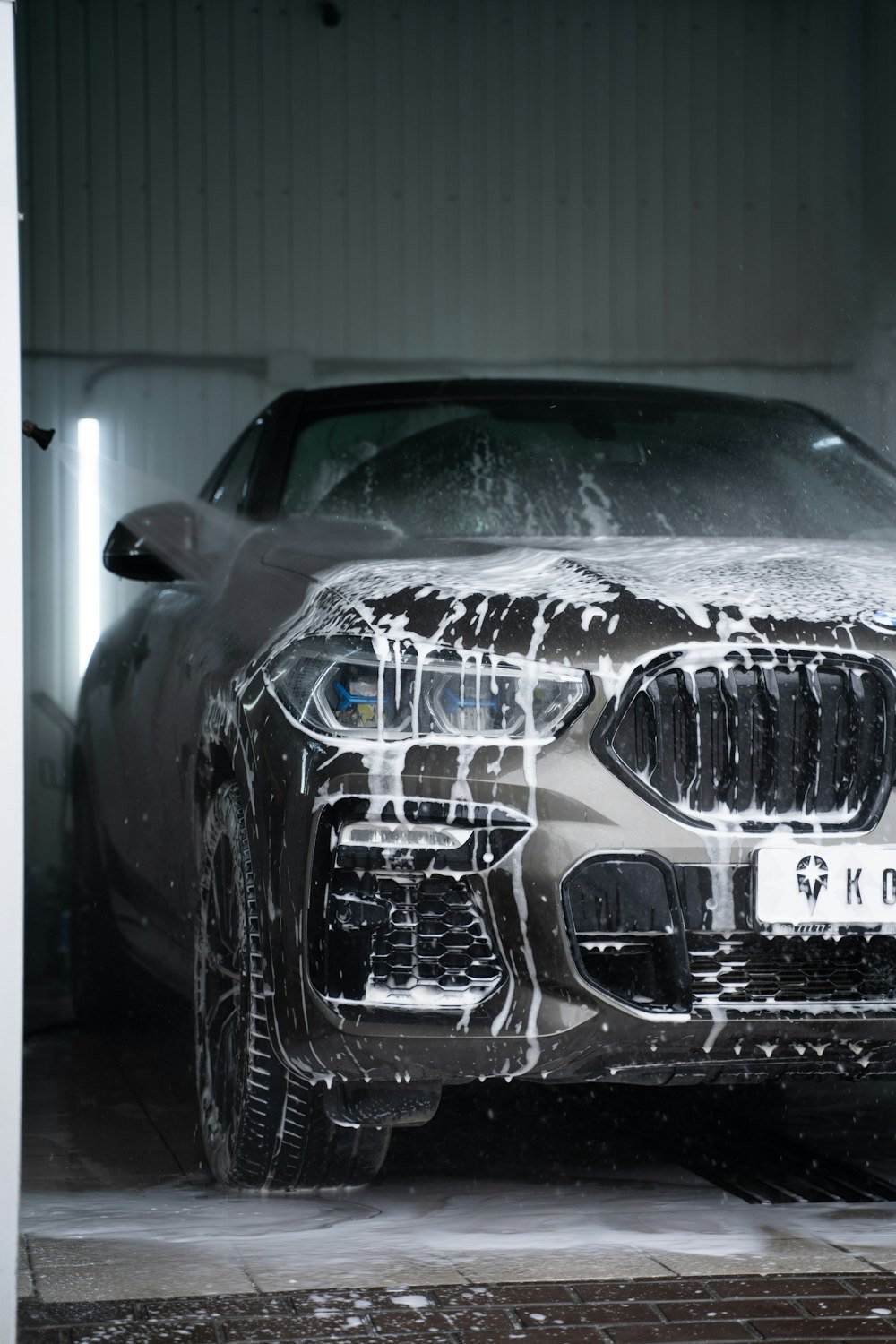 Una macchina è coperta di neve in un garage