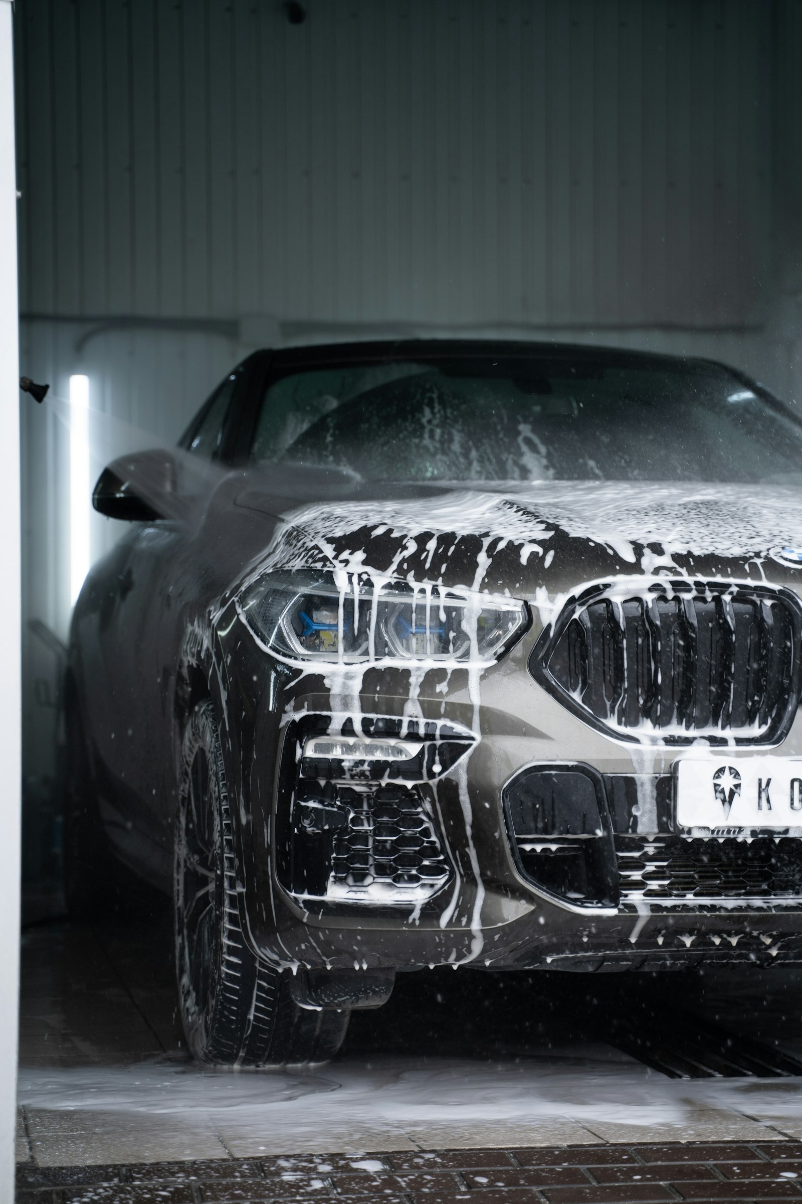 Car covered in thick cleaning foam during a wash