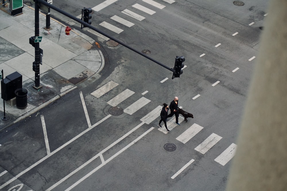 a couple of people walking across a street