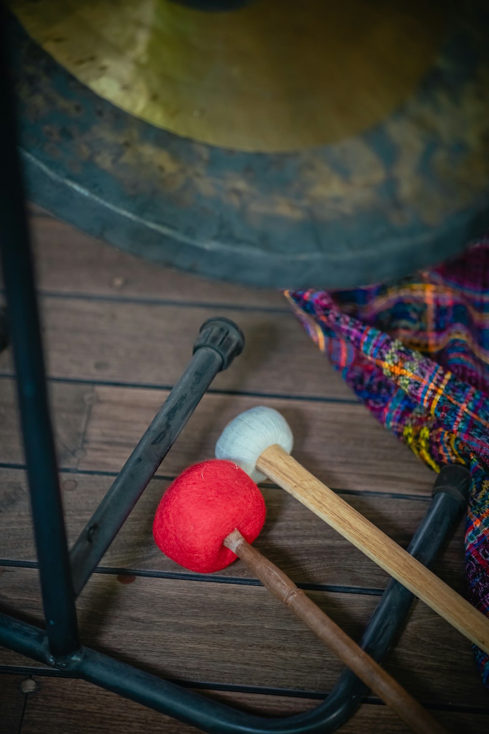 un par de mazos y una bola roja en un piso de madera