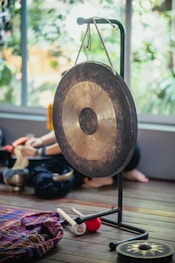 a person sitting on the floor next to a gong