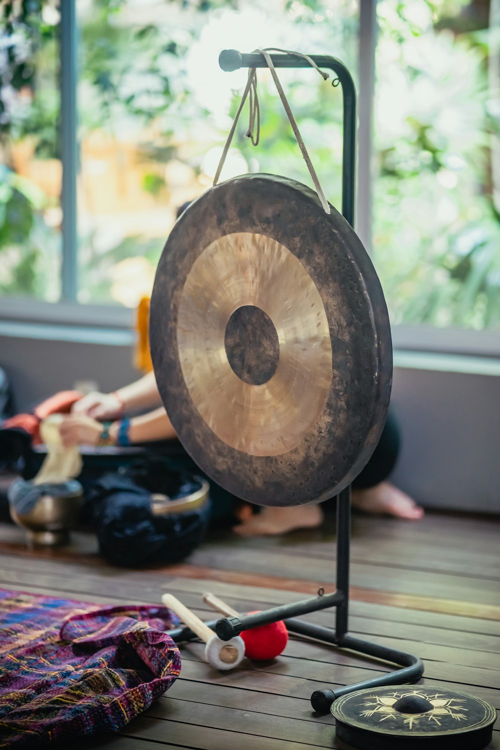 Una persona sentada en el suelo junto a un gong