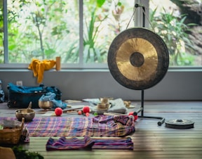 a gong sitting on top of a wooden floor next to a window