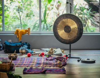 a gong sitting on top of a wooden floor next to a window